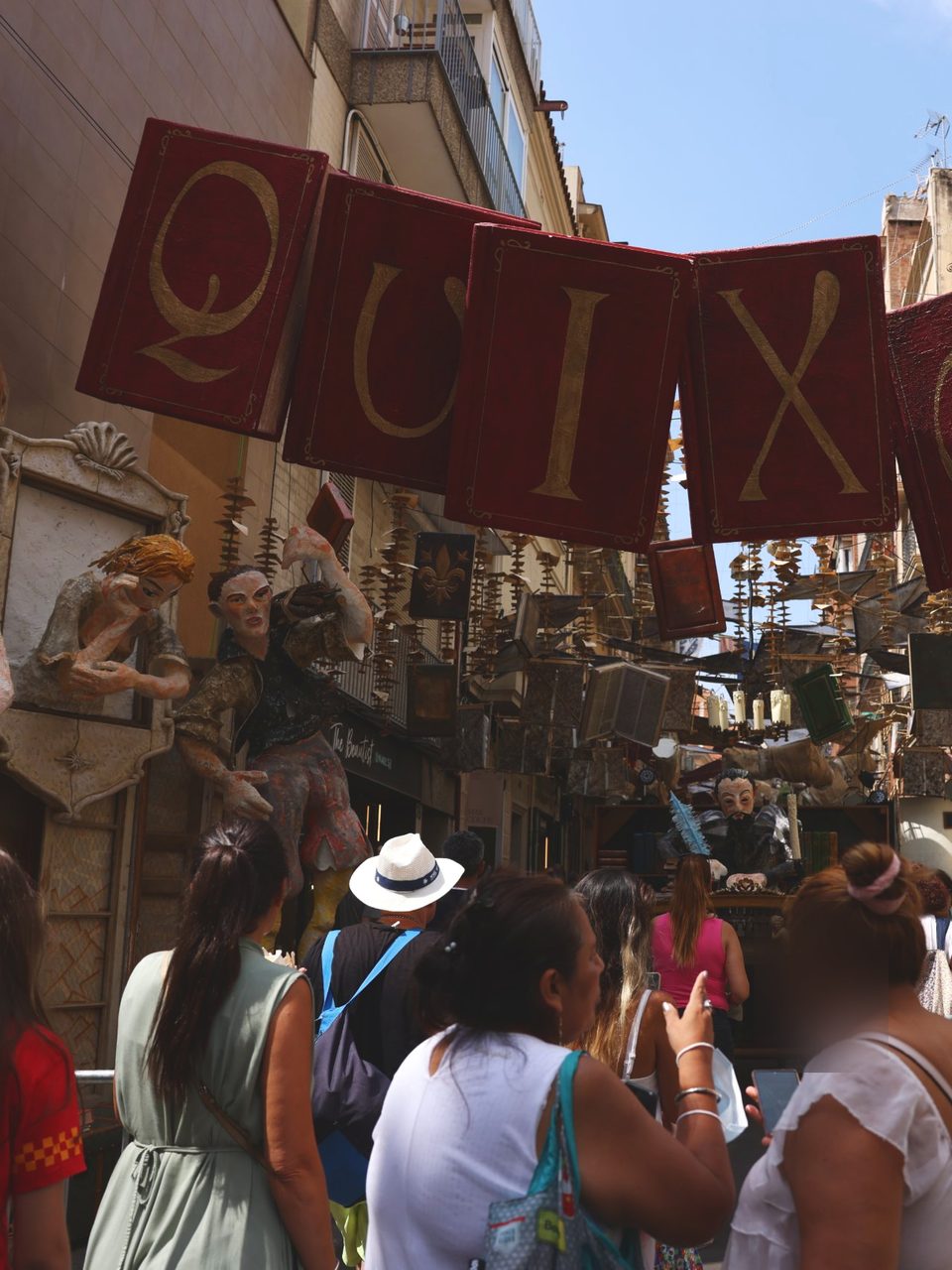 Neighbours walking under a street decorated by its own residents for the Festa de Gràcia.