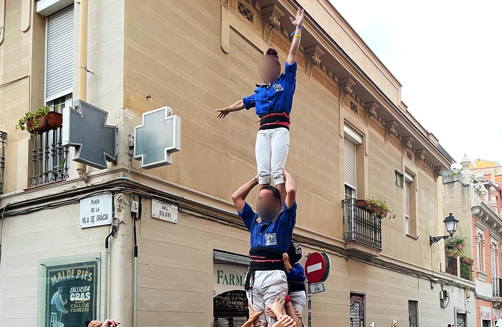 Castellers levantando un castell en Gràcia, sostenido por las manos de la pinya.