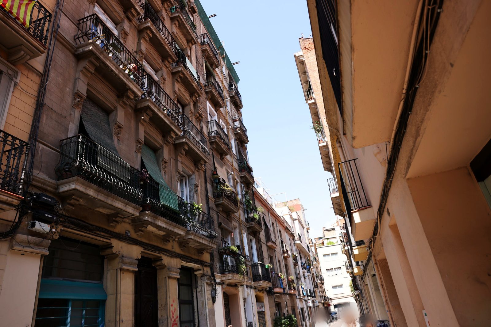 An ordinary residential street of balconies, plants and drying laundry.